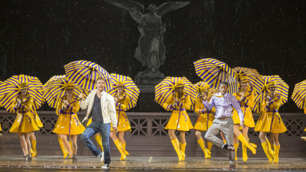 Derek Hough and Jared Grimes dance in the rain with the Rockettes in the New York Spring Spectacular, directed and choreographed by Warren Carlyle, at Radio City Music Hall.