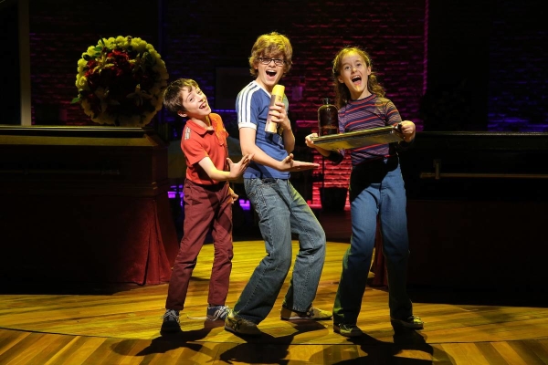 A scene from the Public Theater production of Fun Home, with Sydney Lucas (right) as young Alison Bechdel.