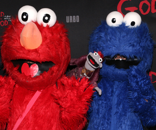 Hand to God star Tyrone McHansley (center) walks the red carpet with special guests Elmo and Cookie Monster.