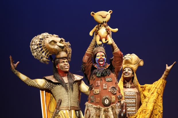 Young Simba flanked by his adoring parents in The Lion King. 
