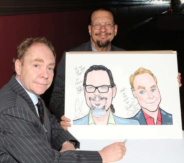 Penn &amp; Teller pose with their caricatures after signing them at Sardi&#39;s.