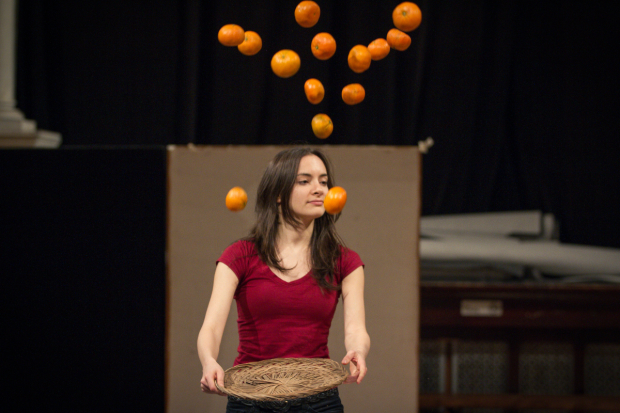 Melanie Neilan throws a plate of oranges into the air in rehearsal.