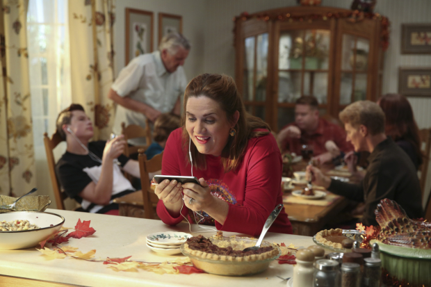 Paula (Donna Lynne Champlin) ignores her family to watch Rebecca&#39;s Thanksgiving dinner from a hidden camera. 