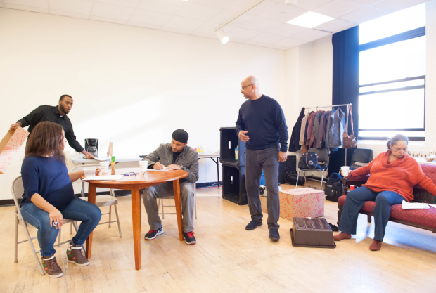 Director Ruben Santiago-Hudson (center) guides his cast in the rehearsal room.