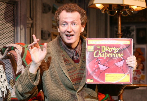 Bob Martin (as Man in Chair) shows off a copy of his favorite cast album, The Drowsy Chaperone.