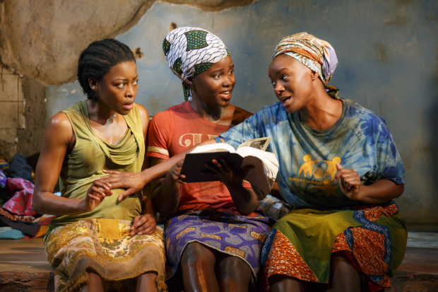 Wife #4 (Lupita Nyong&#39;o, center) reads from a biography of Bill Clinton for Wife #3 (Pascale Armand) and Wife #1 (Saycon Sengbloh) in Eclipsed.