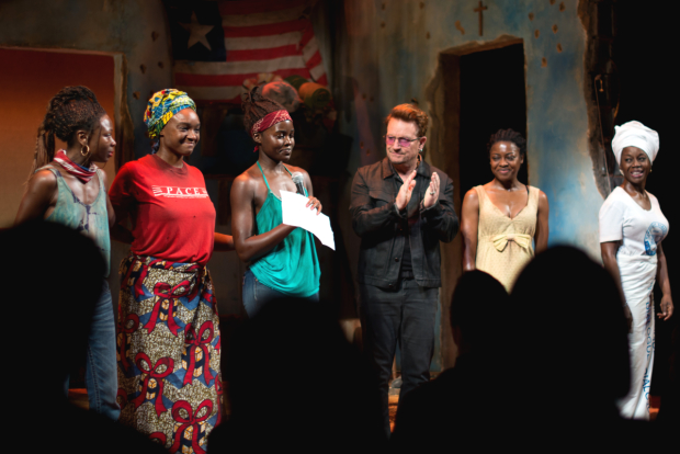 Lupita Nyong&#39;o reads a speech as her costars and Bono look on.