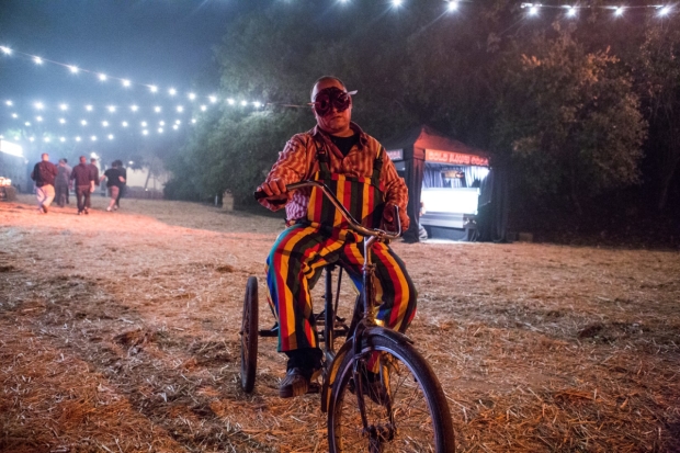 A creepy clown rides a tricycle at the New York Haunted Hayride. 