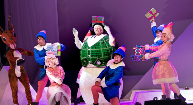 As Sam the Snowman, Steve Watkins (center) leads the elfin chorus in Rudolph the Red-Nosed Reindeer: The Musical.