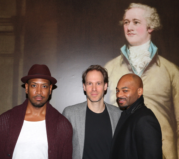 Hamilton family members Bryan Terrell Clark (George Washington), David Korins (set designer), and Brandon Victor Dixon (Aaron Burr) pose with a photograph of Alexander Hamilton at Sotheby&#39;s.