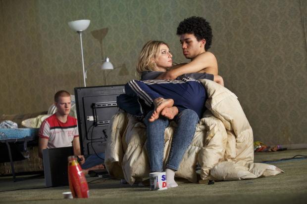 Hench (Lucas Hedges) plays video games as Bobbie (Justice Smith) cuddles with his mother (Ari Graynor) in Yen.