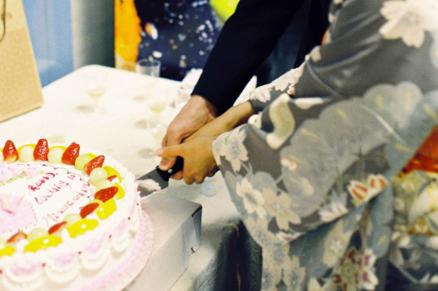 Minami Yusui and Dan Urness cut their wedding cake.