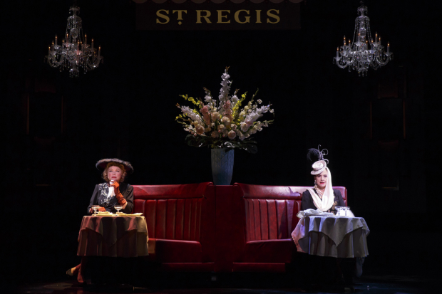 Elizabeth Arden (Christine Ebersole) and Helena Rubinstein (Patti LuPone) sit at separate tables at the St. Regis Hotel in War Paint. 