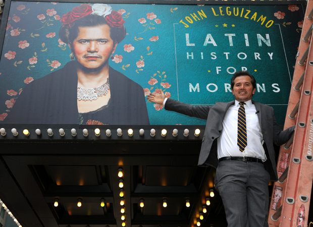 John Leguizamo hops on a ladder to pose with his Broadway marquee.