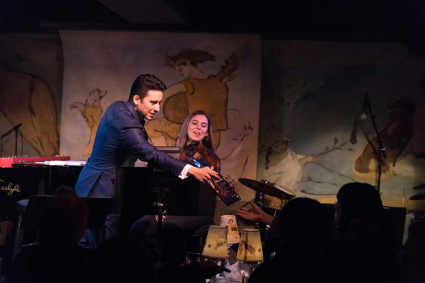 John Lloyd Young hands a copy of the Jersey Boys DVD to an audience member as violinist Gokce Erem looks on.