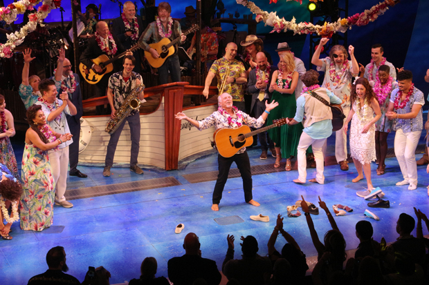 Jimmy Buffett (center) leads the Broadway cast of Escape to Margaritaville in a carefree sing-a-long. 