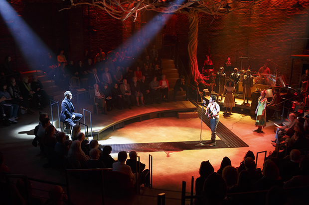 The in-the-round configuration of Hadestown at New York Theatre Workshop included a giant tree as a centerpiece.