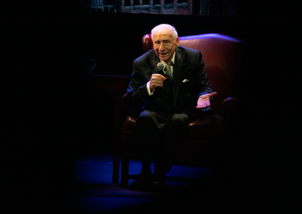 Mel Brooks seated on the Lunt-Fontanne stage.