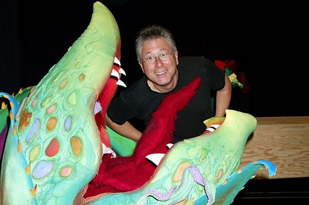 [Composer Alan Menken poses in the jaws of Audrey II during the 2003 Broadway debut of Little Shop of Horrors.
