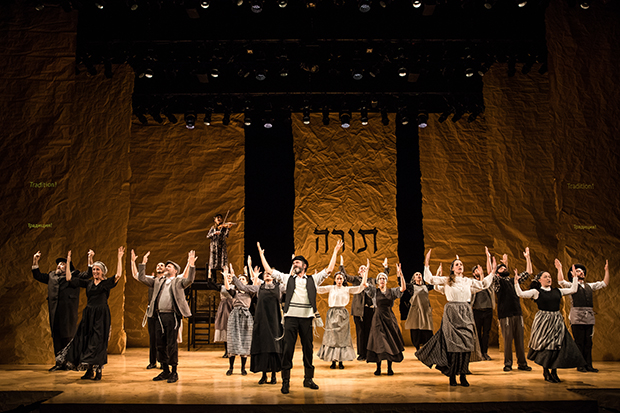 Steven Skybell (center) leads the company of Fiddler on the Roof in Yiddish.