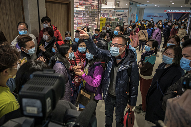 People line up for face masks at a pharmacy in Hong Kong.