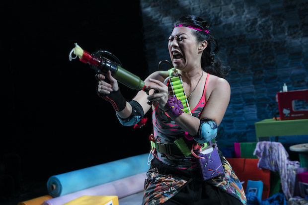Kristina Wong shoots PPE at the audience in Kristina Wong, Sweatshop Overlord.