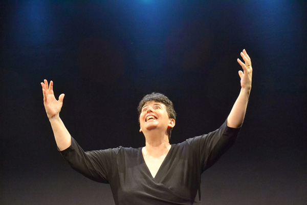 Monica Bauer conducts an imaginary symphony orchestra in her autobiographical solo show The Year I Was Gifted, directed by Carolyn Ladd at Stage Left Studio.