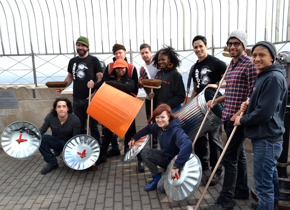 The cast members of Stomp pose with their legendary percussion instruments at the top of the Empire State Building.