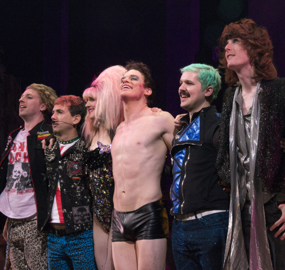Lena Hall and Michael C. Hall (center) take a bow with the members of onstage band Tits of Clay.
