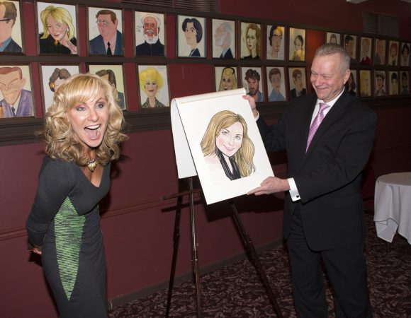 Judy McClane reacts as she sees her caricature for the first time (held by Sardi&#39;s managing partner Max Klimavicius).